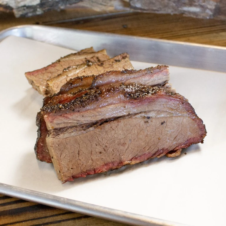 Thick slices of smoked brisket served on butcher paper.