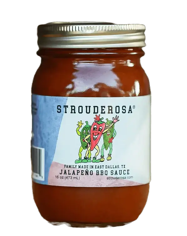 A jar of Strouderosa jalapeño BBQ sauce in front of a Welcome to the Ranch sign